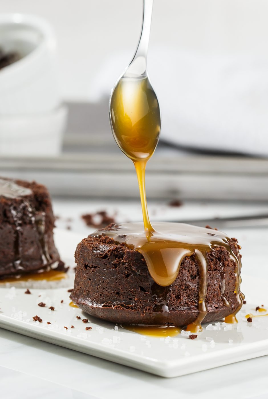Chocolate cake with caramel pouring from a spoon in a bright commercial food image